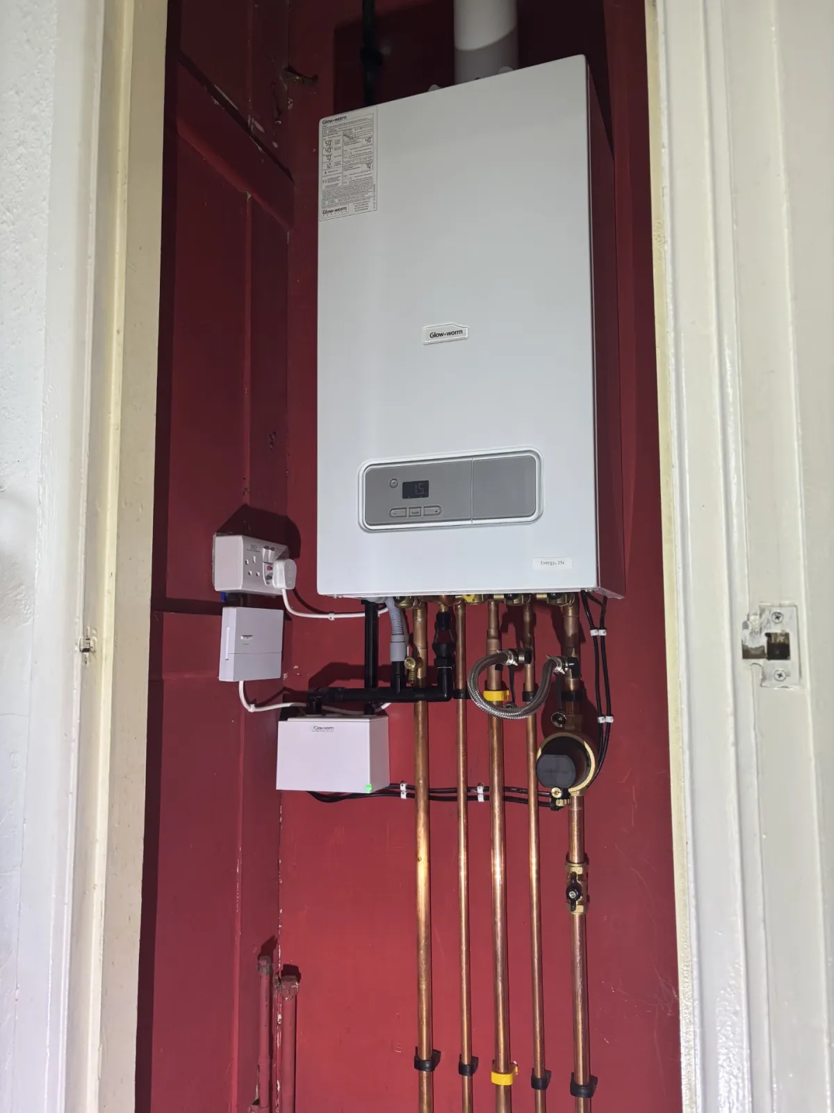 Glow-worm Energy combi boiler fitted in a recessed cupboard with smart control unit alongside
